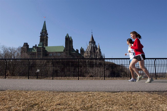 Joggers make their way through Majors Hill Park in downtown Ottawa in view of Parliament Hill on Wednesday, March 17, 2010.