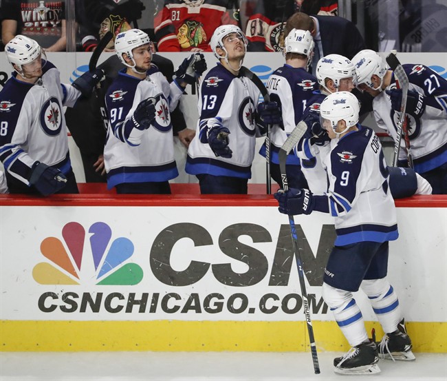 Winnipeg Jets center Andrew Copp, celebrates with teammates after scoring against the Chicago Blackhawks during the third period of an NHL hockey game, Dec. 4, 2016, in Chicago.