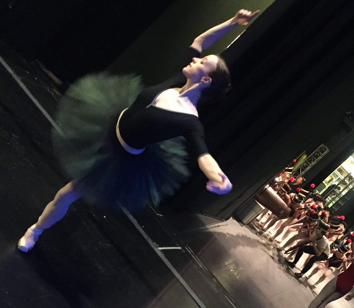 Alberta Ballet company member Jennifer Gibson, who plays the role of the Sugar Plum Fairy this year, warms up backstage as young dancers rehearse their parts on stage.