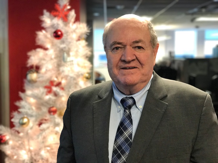 Father John Walsh stands before a Christmas tree at Global News studios in Montreal. Friday, Dec. 23, 2016.
