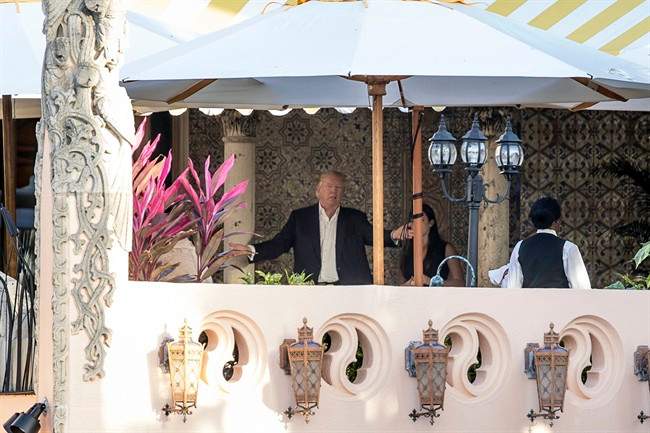 President Donald Trump speaks to an aide at Mar-a-Lago resort in Palm Beach, Fla., Dec. 19, 2016.