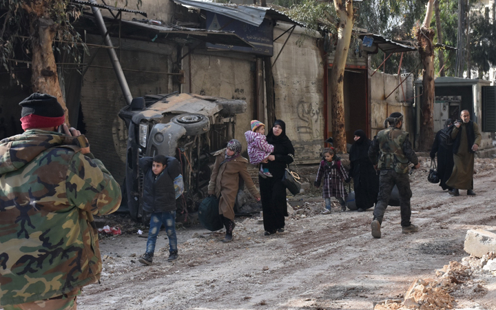 Civilians evacuate Aleppo's al-Shaar neighbourhood after government forces took control of the area in the eastern part of the northern Syrian city on December 7, 2016.