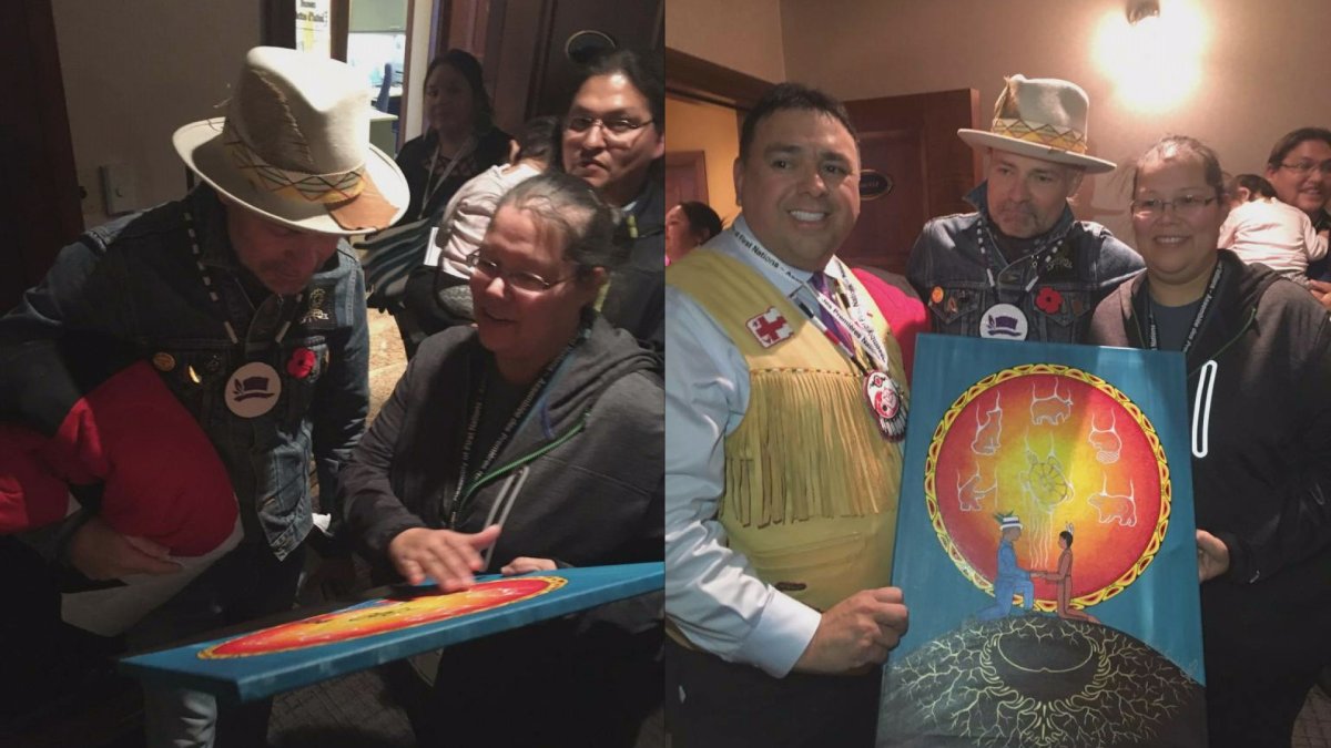 Regional Chief Morley Googoo presents Gord Downie with a painting commissioned for him by Loretta Gould of Wycobah First Nation. The painting depicts Downey meeting Ojibway boy Charlie Wenjack, who inspired Downey's Secret Path project.  