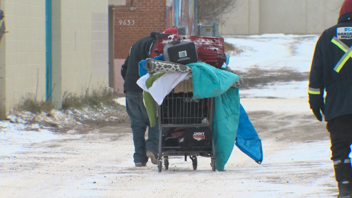 A homeless person pushing a shopping cart of belongings in Edmonton in December 2016.
