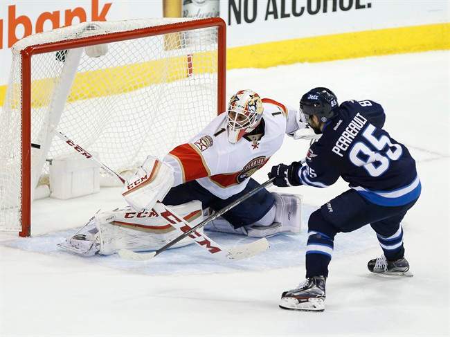 Winnipeg Jets' Mathieu Perreault scores the winning goal in a shootout against Florida Panthers goaltender Roberto Luongo. 