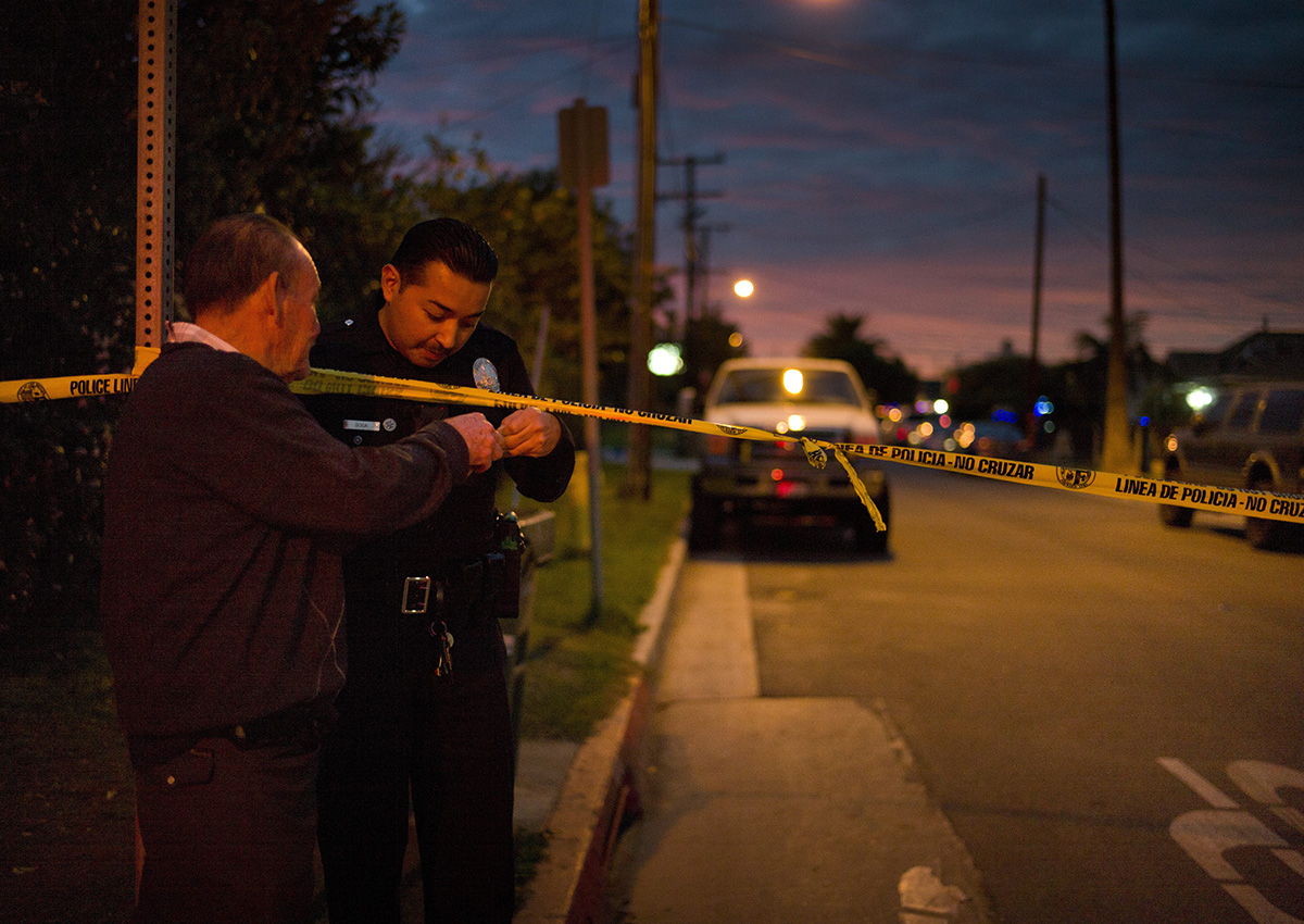 A police officer checks the identification of a man.