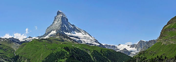 Panoramic view over the Matterhorn mountain with alpine meadows and pine forests in the Swiss Alps, Valais / Wallis, Switzerland. (Photo by: Arterra/UIG via Getty Images).