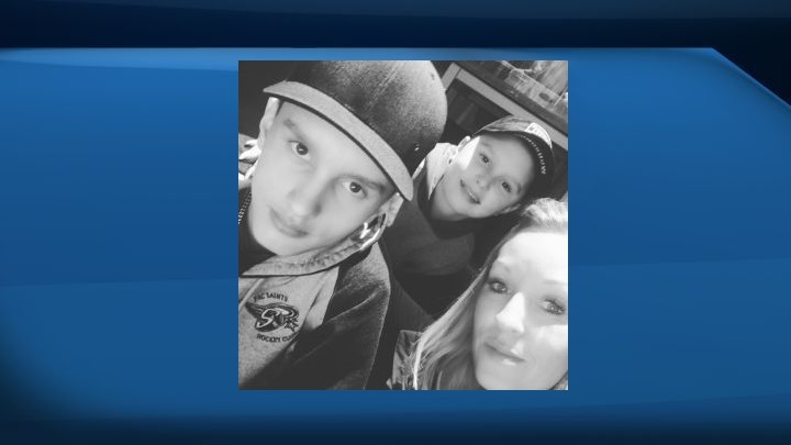 Ryder MacDougall (left) and Radek MacDougall (right) pose for a photo with their mother, Tracy Stark, at an Edmonton Oilers game on Dec. 17, 2016.