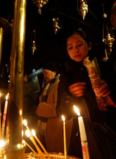 Christian worshippers light candles in the Church of the Nativity, built atop the site where Christians believe Jesus Christ was born, on Christmas Eve, in the West Bank City of Bethlehem, Saturday, Dec. 24, 2016. 
