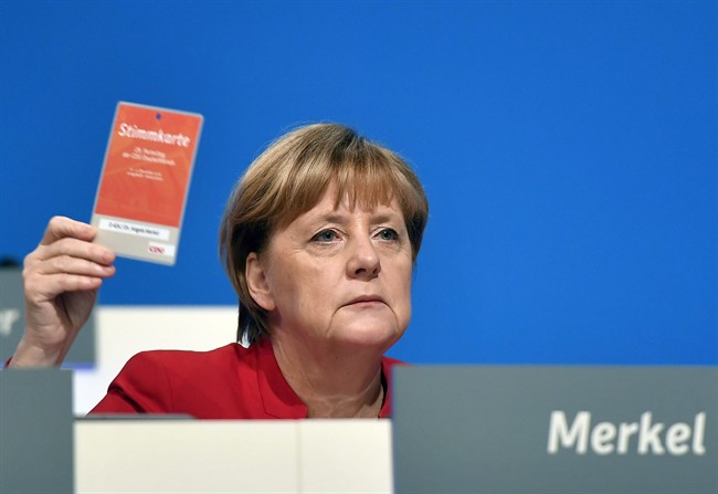 German Chancellor and Chairwomen of the CDU, Angela Merkel, holds an voting ticket during a party conference of the Christian Democratic Union (CDU) in Essen, Germany, Tuesday, Dec. 6, 2016. Chancellor Angela Merkel has won a new two-year term as leader of Germany's main conservative party after she won 89.5 percent of delegates' votes at a party congress. (AP Photo/Martin Meissner).