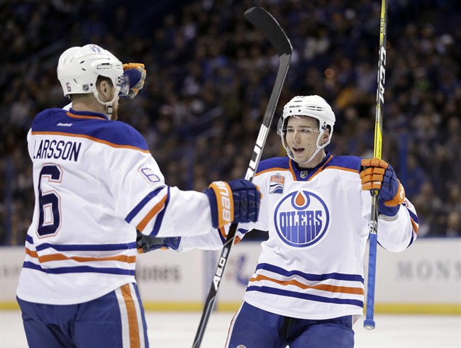 Edmonton Oilers' Tyler Pitlick, right, is congratulated by Adam Larsson, of Sweden, after scoring during the first period of an NHL hockey game against the St. Louis Blues Monday, Dec. 19, 2016, in St. Louis. 