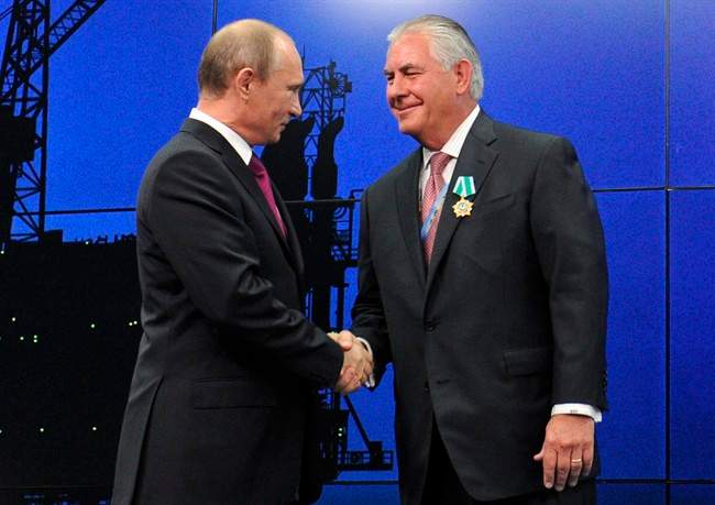 In this photo taken Thursday, June 21, 2012, Russian President Vladimir Putin presents ExxonMobil CEO Rex Tillerson with a Russian medal at an award ceremony of heads and employees of energy companies at the St. Petersburg economic forum in St. Petersburg, Russia.