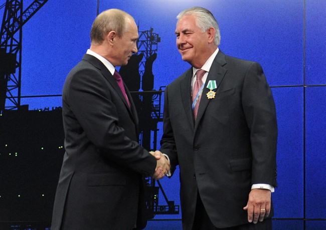 In this photo taken Thursday, June 21, 2012, Russian President Vladimir Putin presents ExxonMobil CEO Rex Tillerson with a Russian medal at an award ceremony of heads and employees of energy companies at the St. Petersburg economic forum in St. Petersburg, Russia.