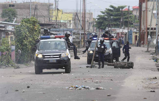 Riot police remove barricade used to block a road during a protest in Kinshasa, Democratic Republic of Congo, Tuesday, Dec. 20, 2016.