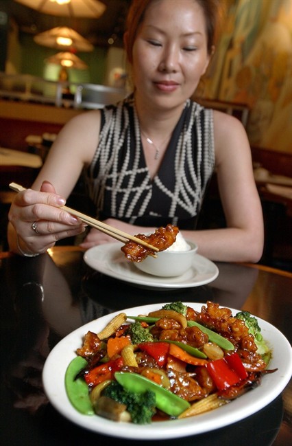 In this July 22, 2004 file photo, Tong Xian Mei, of Ollie's Restaurant, samples from a plate of General Tso's Chicken in New York. Chef Peng Chang-kuei, the chef who has been credited with inventing world-famous Chinese food staple that is not served in China, has died, Wednesday, Nov. 30, 2016. He was 98.
