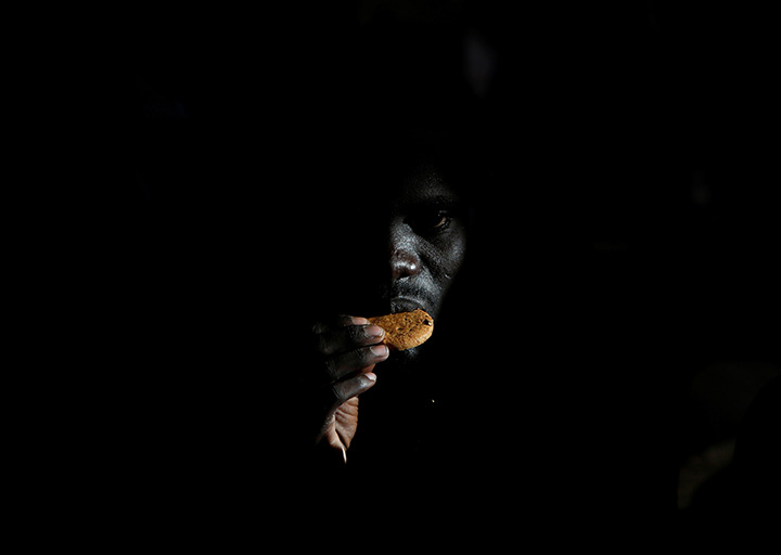 A migrant eats a biscuit on the Migrant Offshore Aid Station ship after being rescued off the coast of Libya on June 23, 2016.
