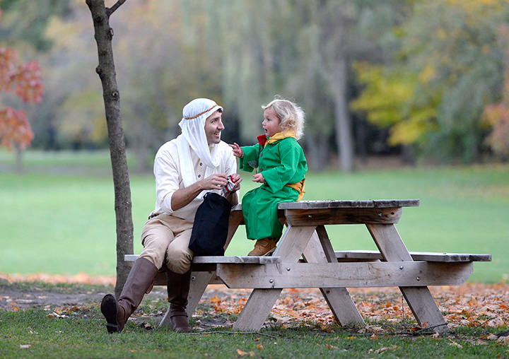Prime Minister Justin Trudeau, dressed as the Pilot from The Little Prince, and his son Hadrien, dressed as the Little Prince, have a treat after trick-or-treating at Rideau Hall on Oct. 31, 2016 in Ottawa.