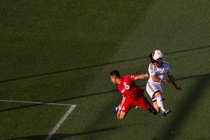 Vancouver Whitecaps’ Christian Bolanos tries to direct a header despite pressure from Toronto FC’s Justin Morrow during first half Canadian Cup action in Toronto on June 21, 2016.