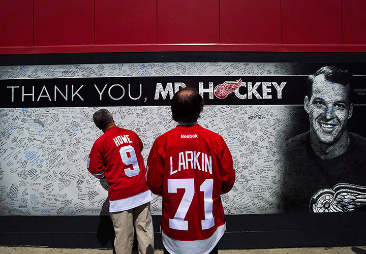 A man signs a memorial wall as thousands of people line up to pay their respects to Gordie Howe as the casket rests in the Joe Louis Arena in Detroit on June 14, 2016.