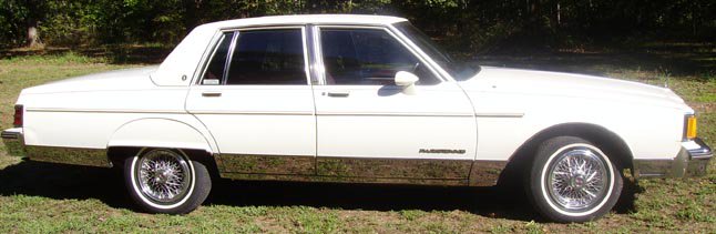 A white mid-1980s four-door Sedan.