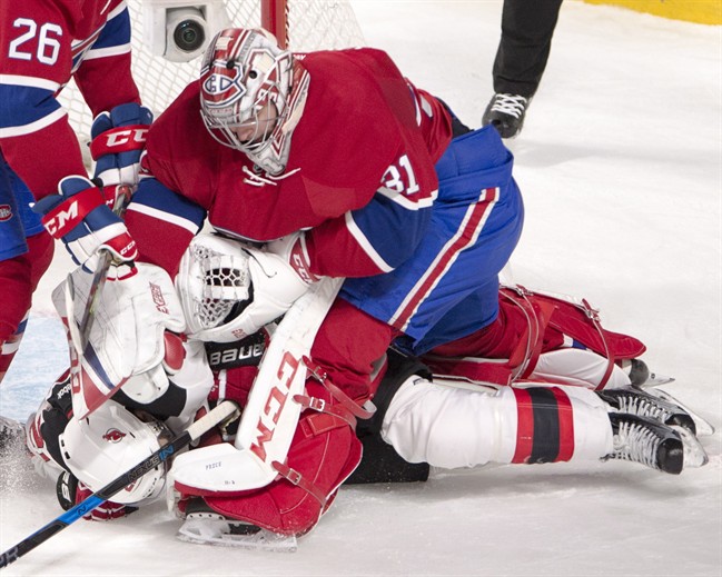 Montreal Canadiens goalie Carey Price (31) punches New Jersey Devils right wing Kyle Palmieri (21) after Palmieri ran into him during first period NHL hockey action Thursday, December 8, 2016 in Montreal.