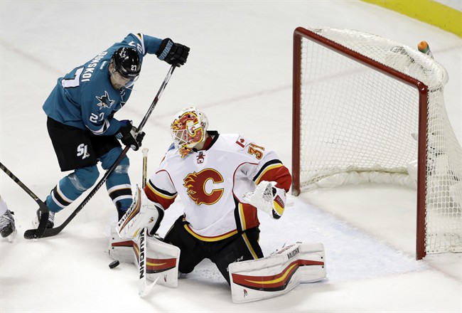 Calgary Flames' Chad Johnson, right, deflects a shot next to San Jose Sharks' Joonas Donskoi during the first period of an NHL hockey game Tuesday, Dec. 20, 2016, in San Jose, Calif. 