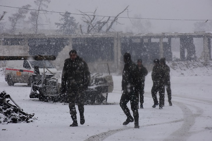 Syrian pro-government forces walk as snow falls in Aleppo on December 21, 2016.
The last residents hoping to leave rebel-held Aleppo waited in the snow as delays hit an evacuation that will leave Syria's army in full control of the devastated city.

Images).