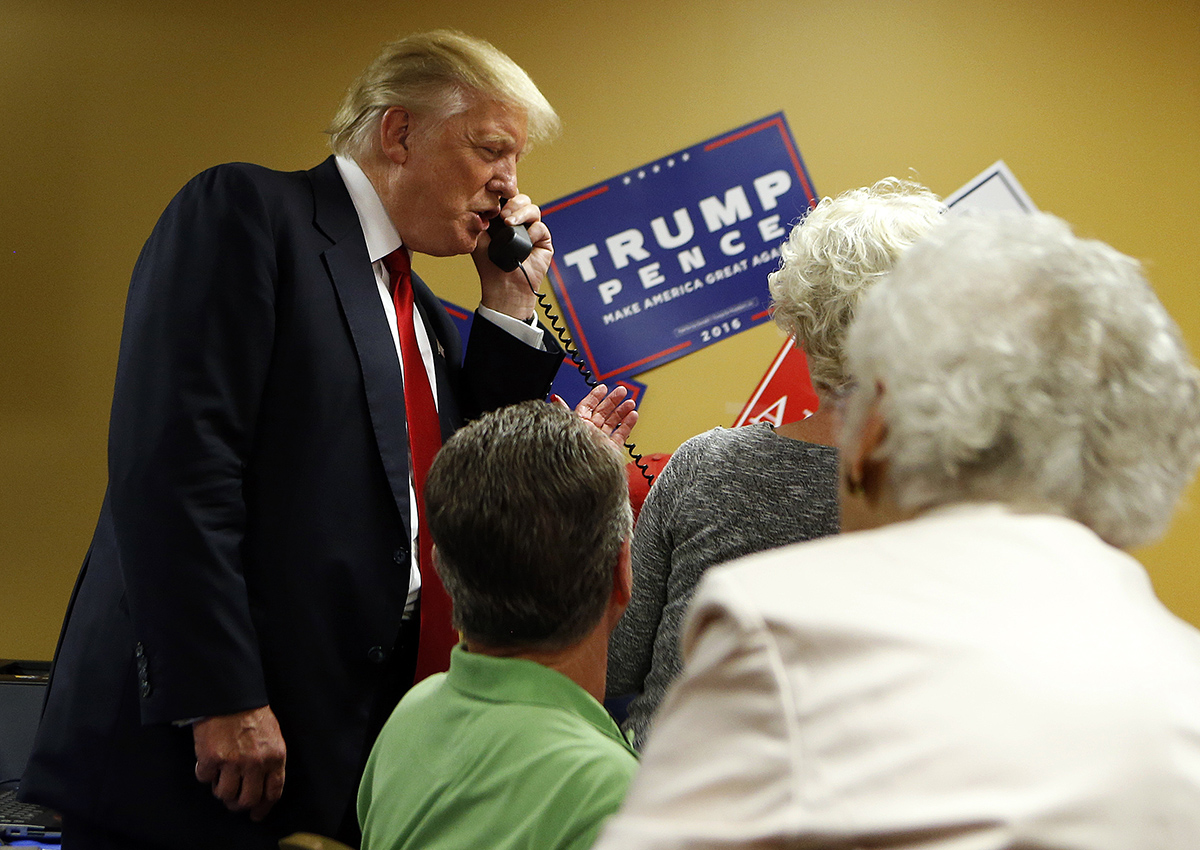 Republican presidential candidate Donald Trump speaks to a caller on the other end of the phone line as volunteers man a phone bank prior to a rally on September 12, 2016 at U.S. Cellular Center in Asheville, North Carolina. 