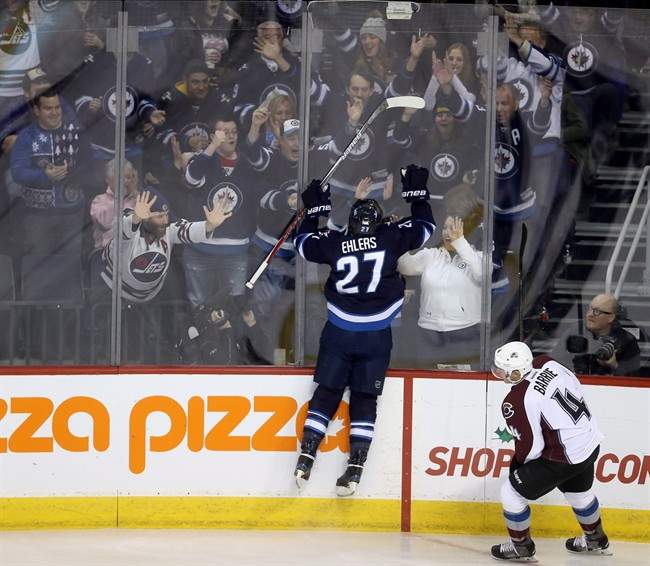 Winnipeg Jets' Nikolaj Ehlers (27) celebrates his third period goal as Colorado Avalanche's Tyson Barrie (4) looks on during third period NHL hockey action in Winnipeg, Sunday, December 18, 2016. 