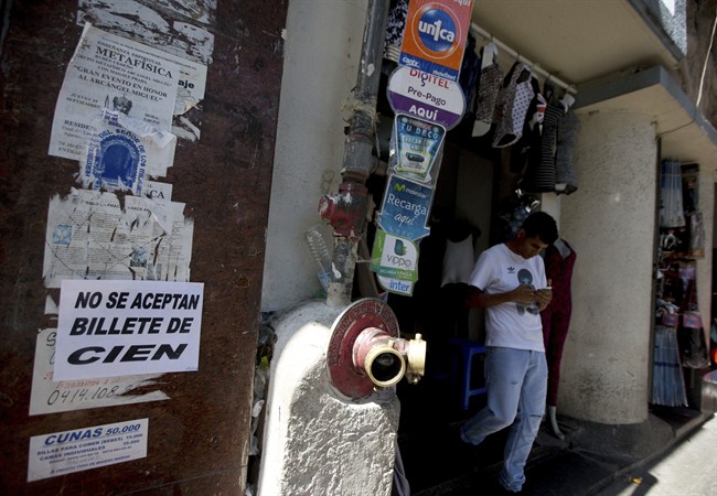 A customer who tried to make a purchase with 100-bolivar notes leaves a shop with a message posted in Spanish: "not accepting the 100 bank note ", in Caracas, Venezuela, Thursday, Dec. 15, 2016. Today is latest deadline for Venezuelan's to exchange 100-bolivar bank notes, which the government is removing from circulation.