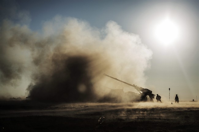 French soldiers shoot a canon toward Islamic State militant positions from a coalition forces military base in Qayara, Iraq, Saturday, Dec. 10, 2016. Teams are poised to prevent the spread of Islamic State fighters after the Iraqi city of Mosul falls.
