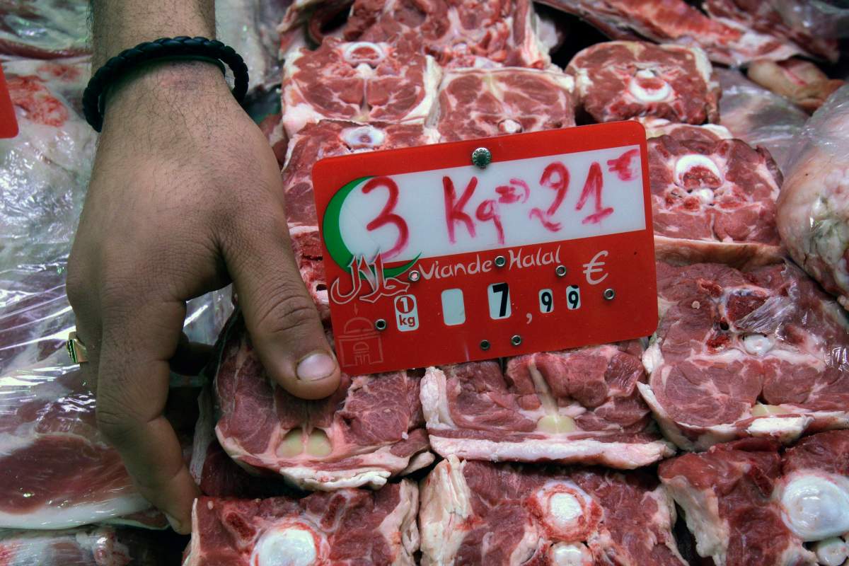 In this photo taken Friday, March 9, 2012, a butcher arranges halal meat at a butcher shop in Paris.