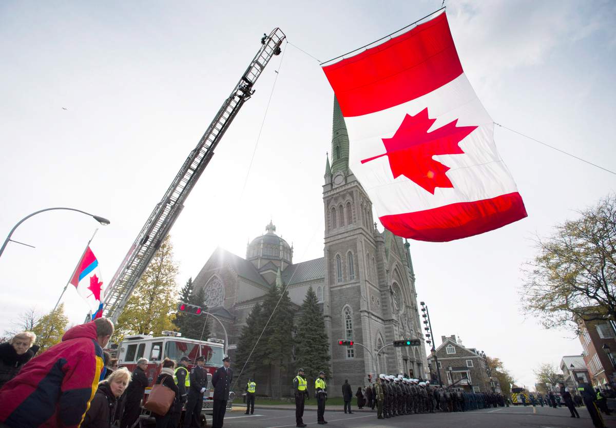 A Canadian flag flies outside the church prior to the funeral of warrant officer Patrice Vincent in Longueuil, Que., Saturday, Nov. 1, 2014.