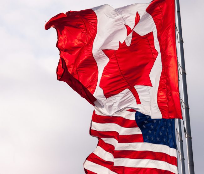 Canadian and American flags fly beside each other in Sarnia, Ont., Oct. 18, 2016. 