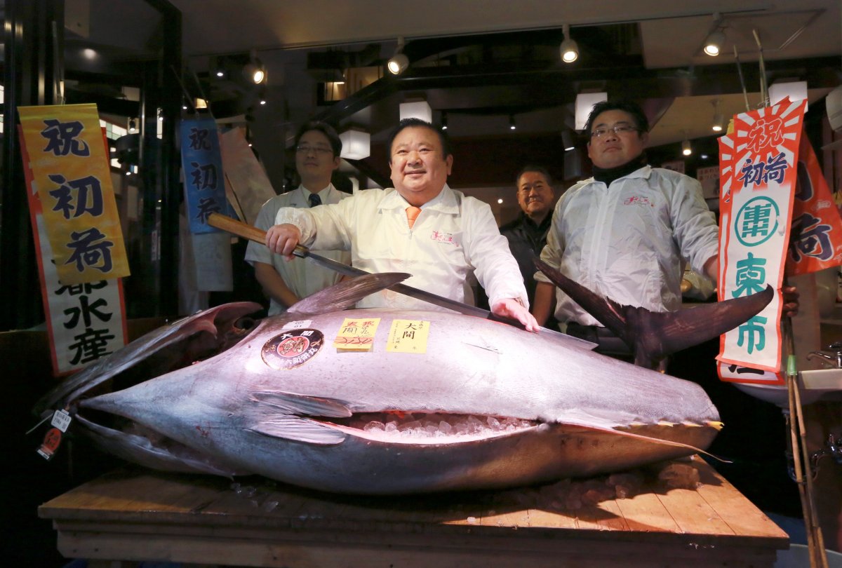 Kiyoshi Kimura, center, president of Kiyomura Co., poses with a bluefin tuna at his Sushi Zanmai restaurant near Tsukiji fish market in Tokyo, early Thursday, Jan. 5, 2017. The Japanese sushi chain boss bid a winning 74.2 million yen (C$846,247.95) Thursday for the 212 kilogram (466 pound) bluefin tuna in what may be Tsukiji market's last auction at its current site in downtown Tokyo. 