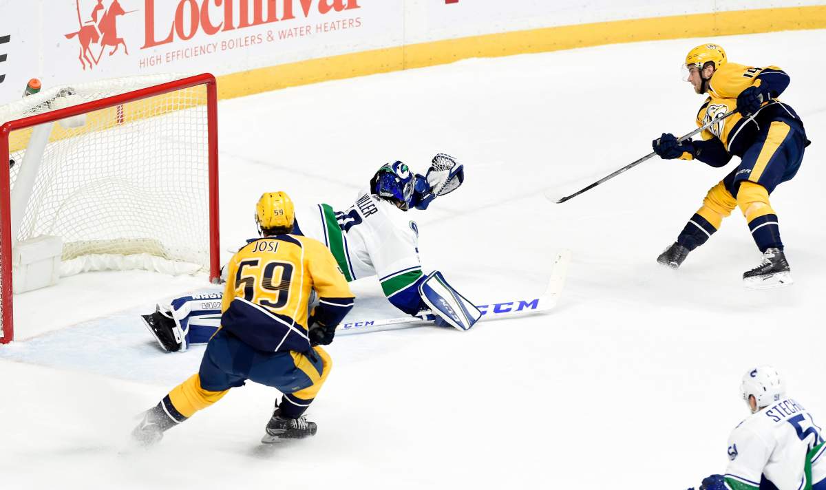 Nashville Predators center Calle Jarnkrok, top right, of Sweden, scores a goal against Vancouver Canucks goalie Ryan Miller (30) as defenseman Roman Josi (59), of Switzerland, watches in overtime of an NHL hockey game Tuesday, Jan. 10, 2017, in Nashville, Tenn. The Predators won 2-1. 