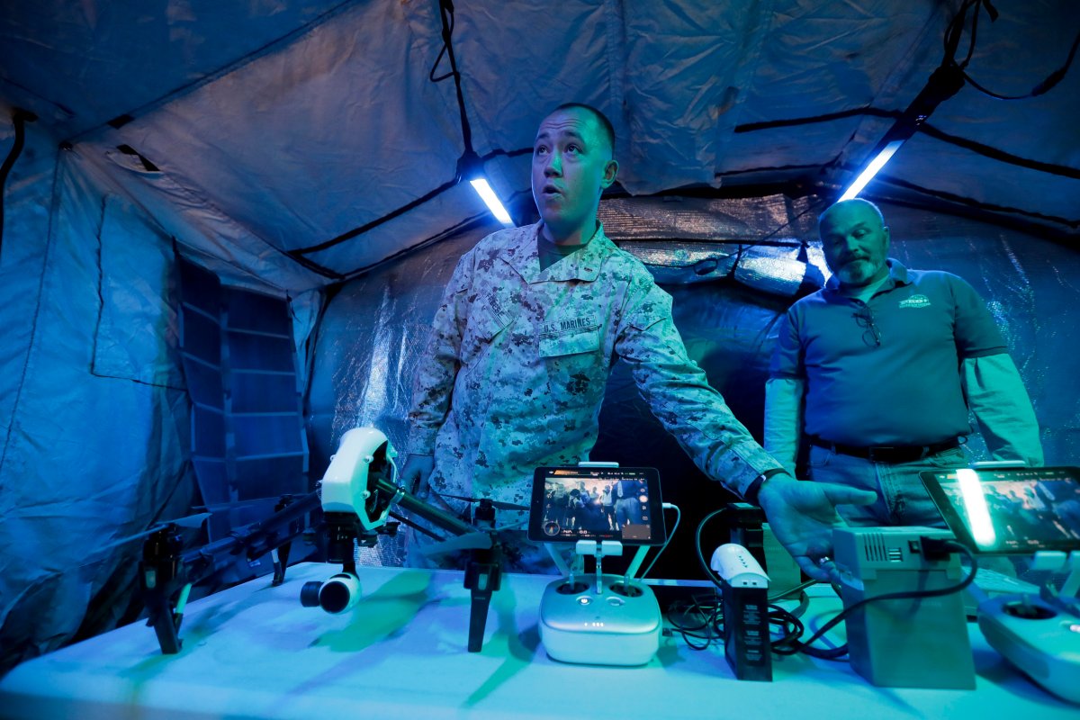 In this Dec. 7, 2016 photo, Marine Chief Warrant Officer Chad Freese displays a solar-powered drone during an exhibition of green energy technology in Twentynine Palms, Calif. The Marine Corps and Navy have led an unprecedented push to ease the Department of Defense's reliance on fossil fuels under the Obama administration. Those projects championed under Obama now face uncertainty under President-elect Donald Trump, who has chosen a Cabinet with climate change skeptics and fossil fuel promoters. 