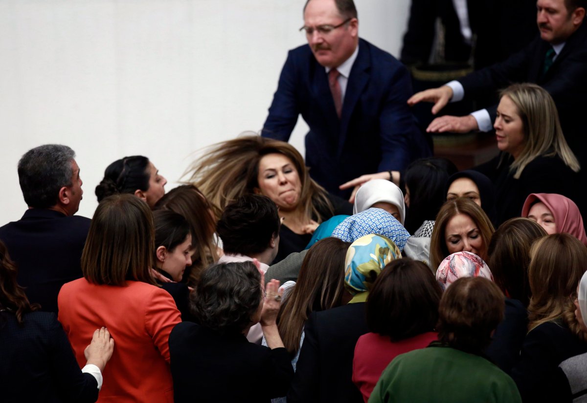 Independent legislator Aylin Nazliaka, third right, and ruling party lawmaker argue after she handcuffed herself to the parliament's rostrum in protest at a contentious reform package that would give President Recep Tayyip Erdogan's office executive powers, sparking fighting between women legislators who were seen slapping each other, in Ankara, Turkey, early Thursday, Jan. 19, 2017. The move sparked fighting between female legislators that reportedly resulted in two of them being hospitalized.