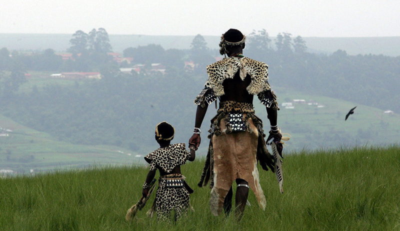 A man and his son, members of the Shembe Church, dressed in tribal leopard skins at the end of a pilgrimage on the holy Nlangakazi Mountain north of Durban, South Africa. 