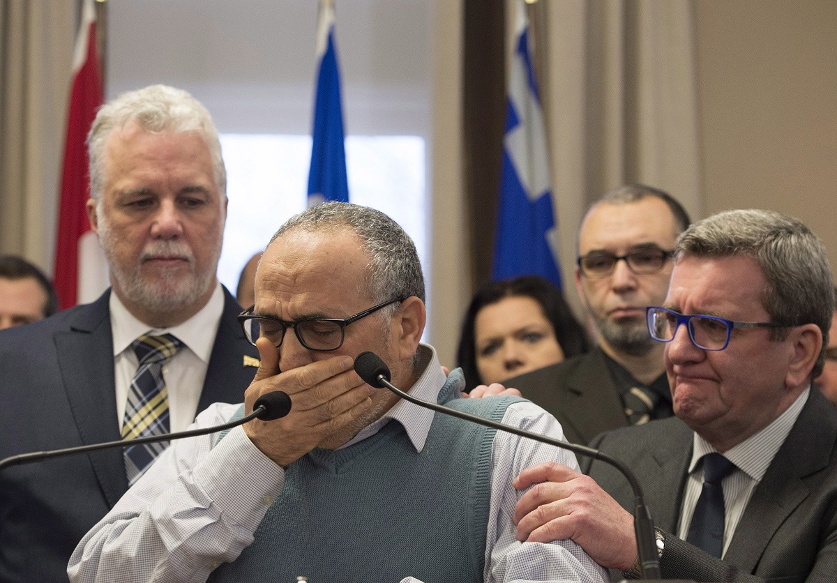 Mohamed Labidi, vice-president of the Islamic cultural centre, is comforted by Quebec Premier Philippe Couillard, left, and Quebec City mayor Regis Labeaume, right, during a news conference about the deadly shooting at a mosque in Quebec City on Monday, January 30, 2017. 
