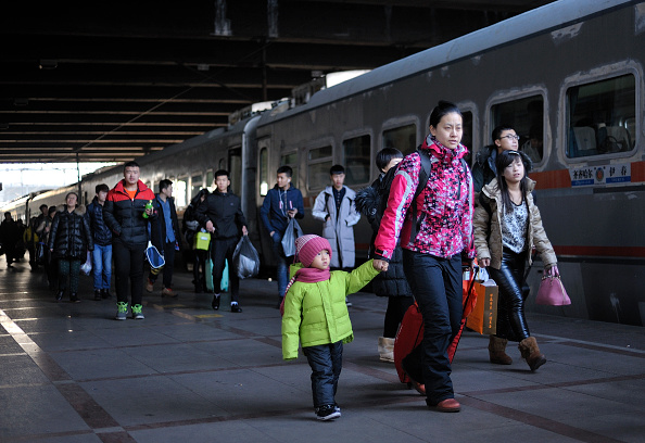 Chinese passengers passing on the platform passing by the train at the Harbin Railway Station on the the annual spring migration in Harbin city, China, 05 February 2016. (Photo by NurPhoto/NurPhoto via Getty Images).