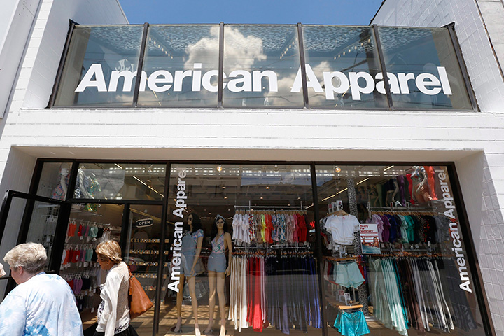 In this Wednesday, July 9, 2014, file photo, passers-by walk in front of the American Apparel store in Pittsburgh. 