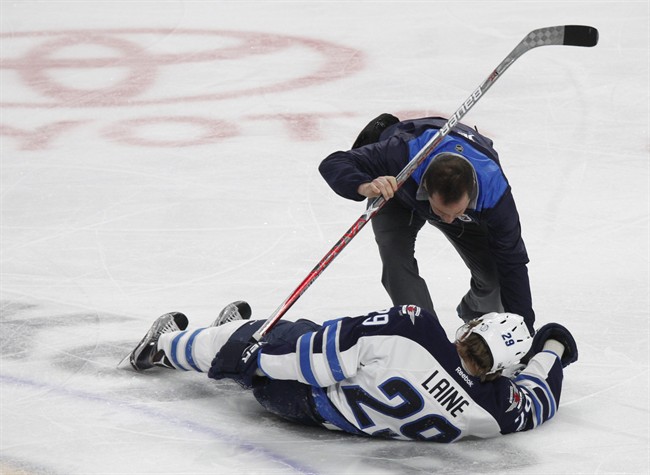 Winnipeg Jets forward Patrik Laine is helped by a trainer after being hit during a game against the Buffalo Sabres on Jan. 7.