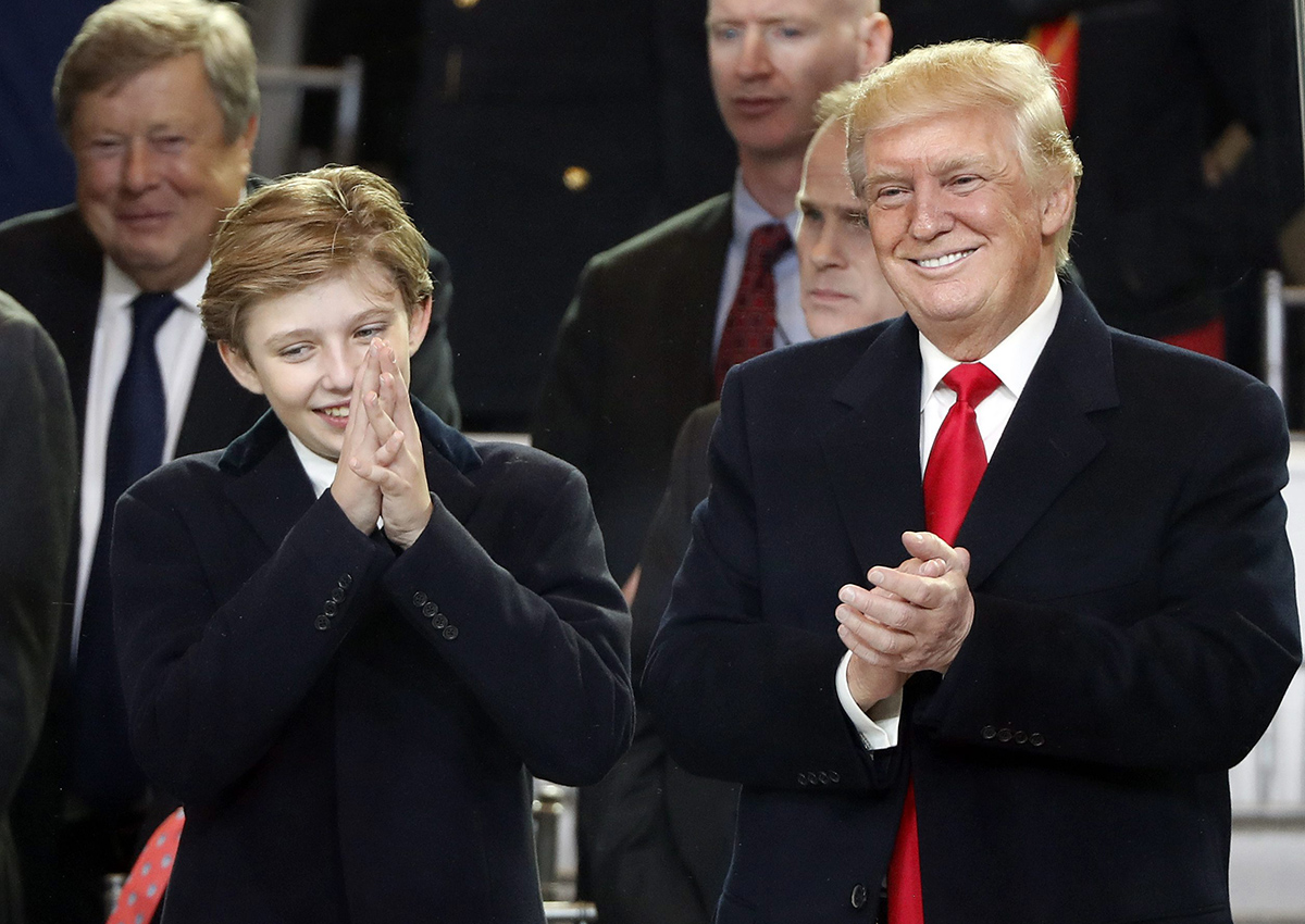 President Donald Trump, right, smiles with his son Barron as they view the 58th Presidential Inauguration parade for President Donald Trump in Washington. Friday, Jan. 20, 2017.