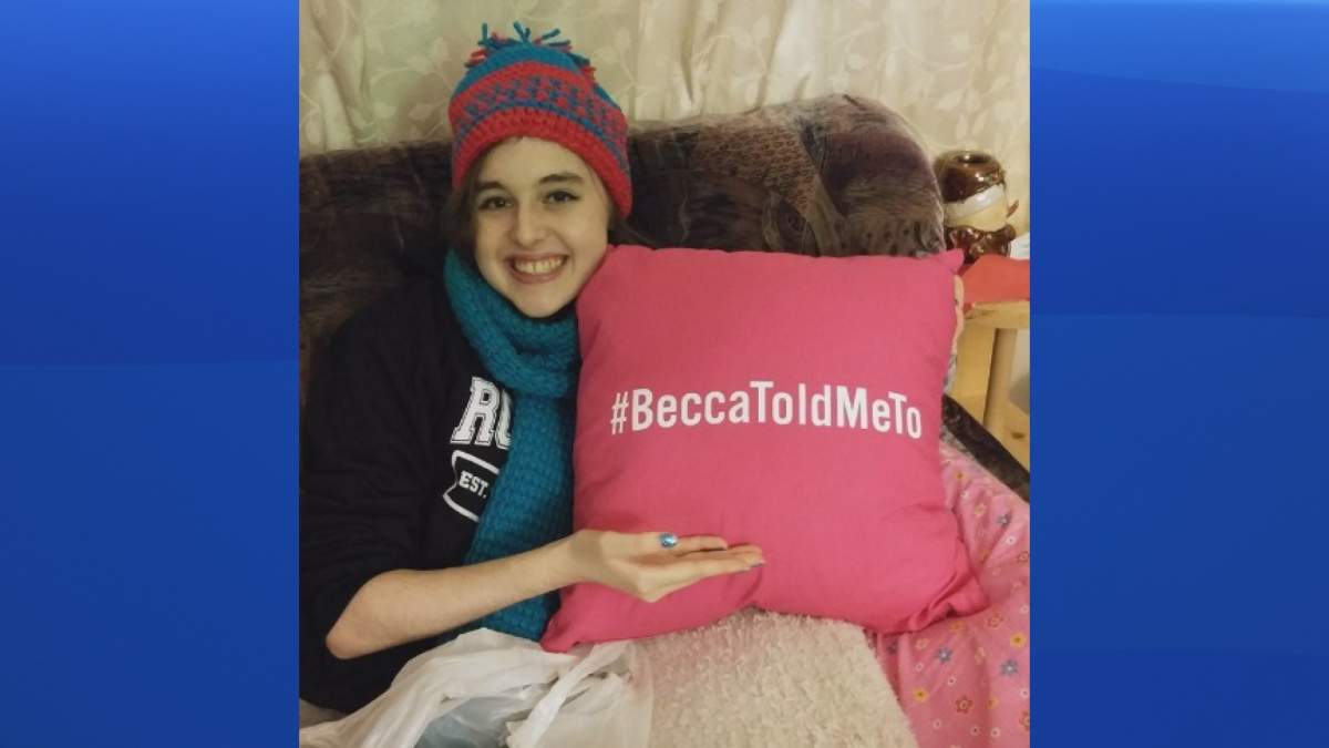 Becca Schofield, a Riverview, N.B. teenager battling terminal brain cancer, holds a pillow with a hashtag she asked people to use in December to chronicle when they performed acts of kindness in her honour. 