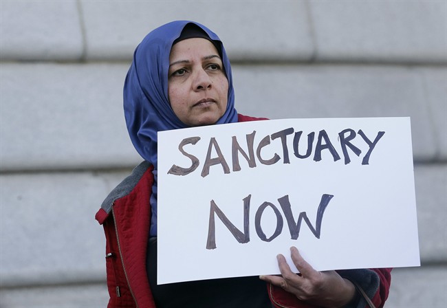Moina Shaiq holds a sign at a rally outside of City Hall in San Francisco, Wednesday, Jan. 25, 2017. President Donald Trump moved aggressively to tighten the nation's immigration controls Wednesday, signing executive actions to jumpstart construction of his promised U.S.-Mexico border wall and cut federal grants for immigrant-protecting "sanctuary cities."