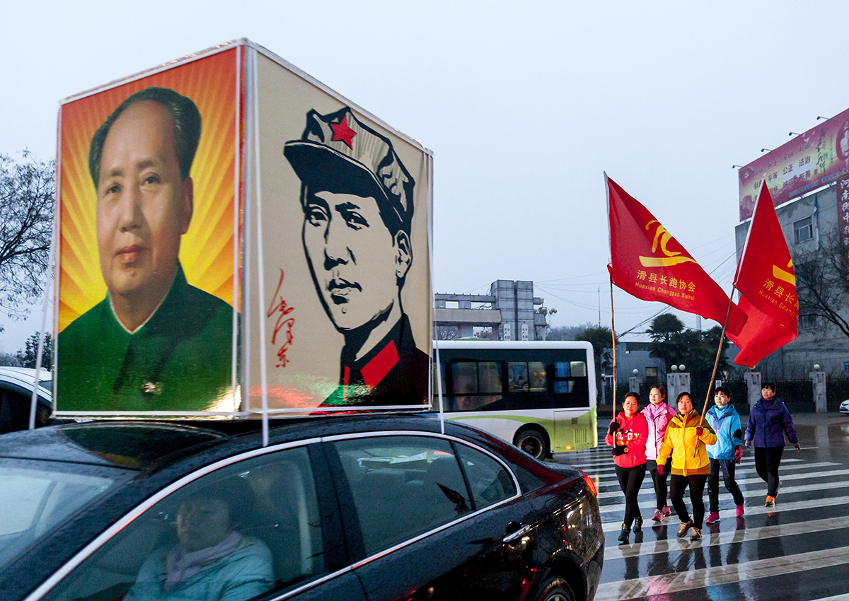 People holding flags and Mao's portraits parade to commemorate the 123rd anniversary of Chairman Mao Zedong's birthday on December 26, 2016 in Huaxian County, China. 