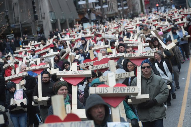 Residents, activists, and friends and family members of victims of gun violence march down Michigan Avenue carrying nearly 800 wooden crosses bearing the names of people murdered in the city in 2016 on December 31, 2016 in Chicago, Illinois.