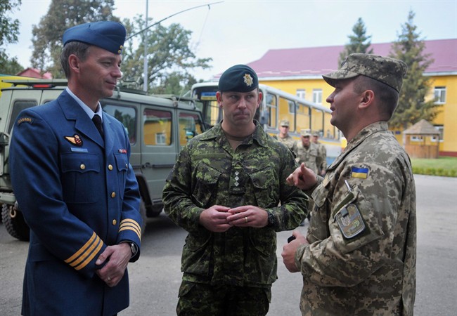 Canadian and Ukrainian servicemen talk during the opening ceremony of a joint military exercises in Lviv, Ukraine, Monday, Sept. 14, 2015. Ukraine's envoy says his country is growing concerned about whether Canada will continue its future military support to his country to help it deter Russian aggression.