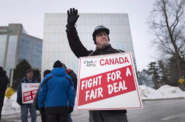 Eric Wynne waves to a supporter while joining other Halifax Chronicle Herald newsroom union members as they picket outside the newspaper's office after walking off the job in Halifax on Saturday, January 23, 2016.